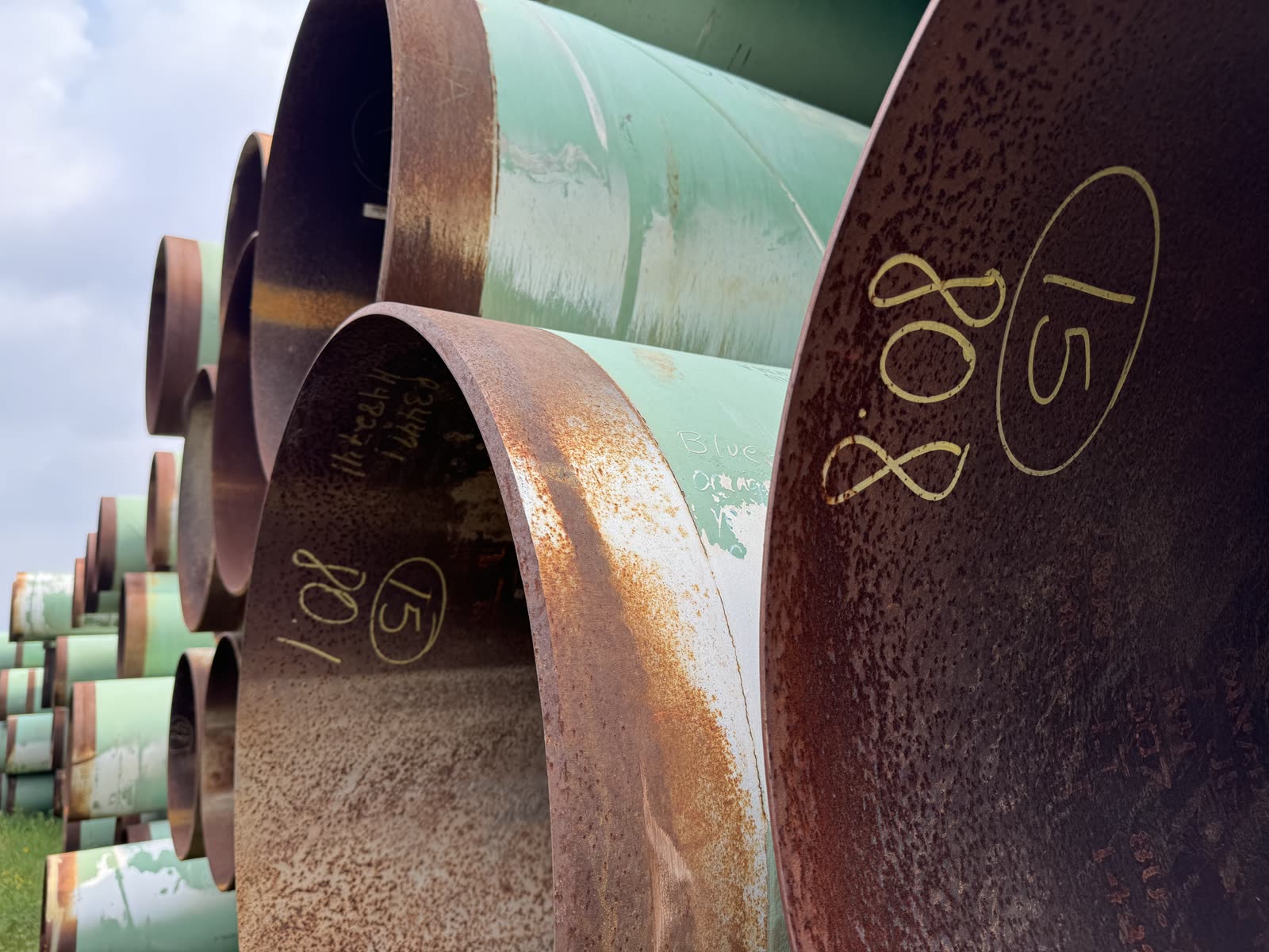 Ends of stacked coated line pipe, tallied and marked in the yard
