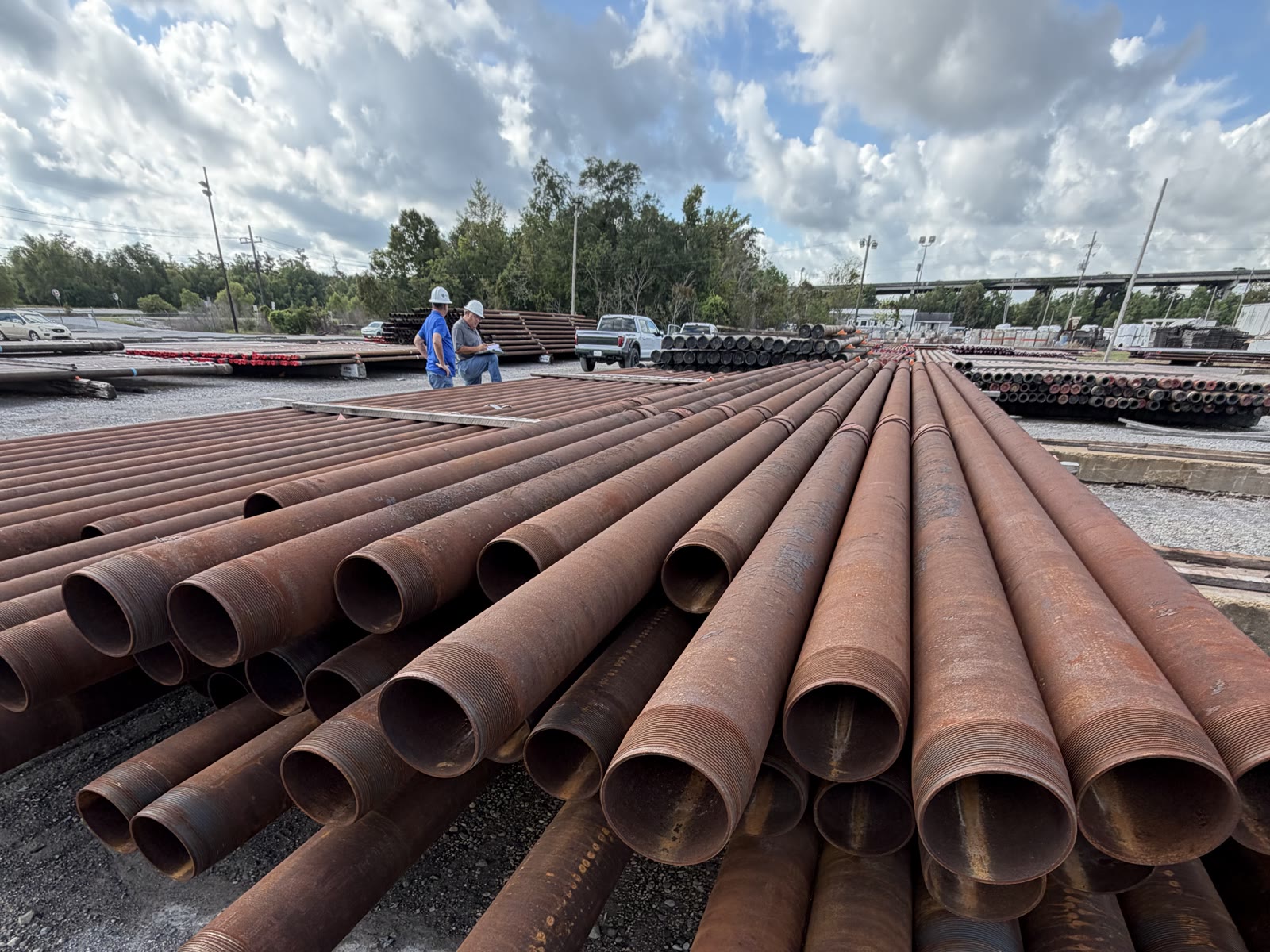 Bundles of surplus steel pipe fanned out on the ground, mixed diameters