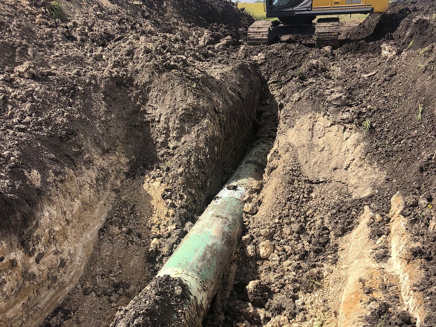 Coated line pipe exposed in the ditch