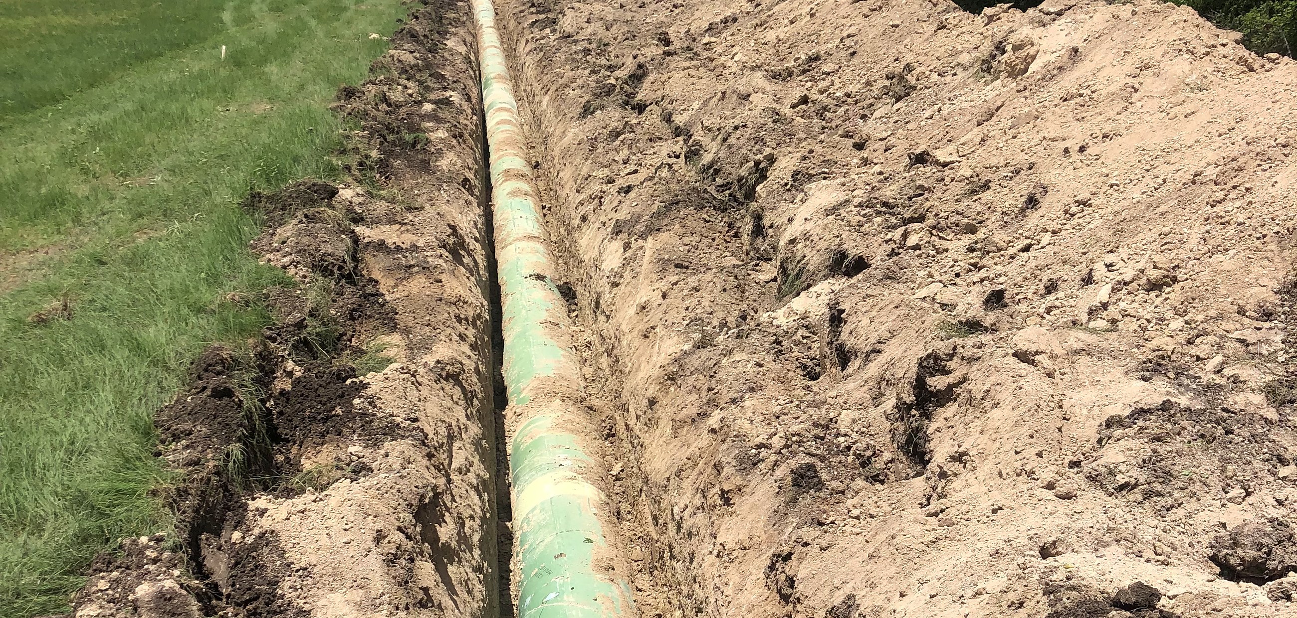 Exposed line pipe running the length of an open right-of-way