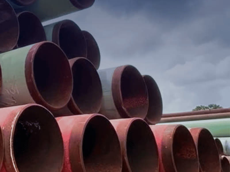 Stacked line pipe of mixed diameters and coatings under an overcast sky