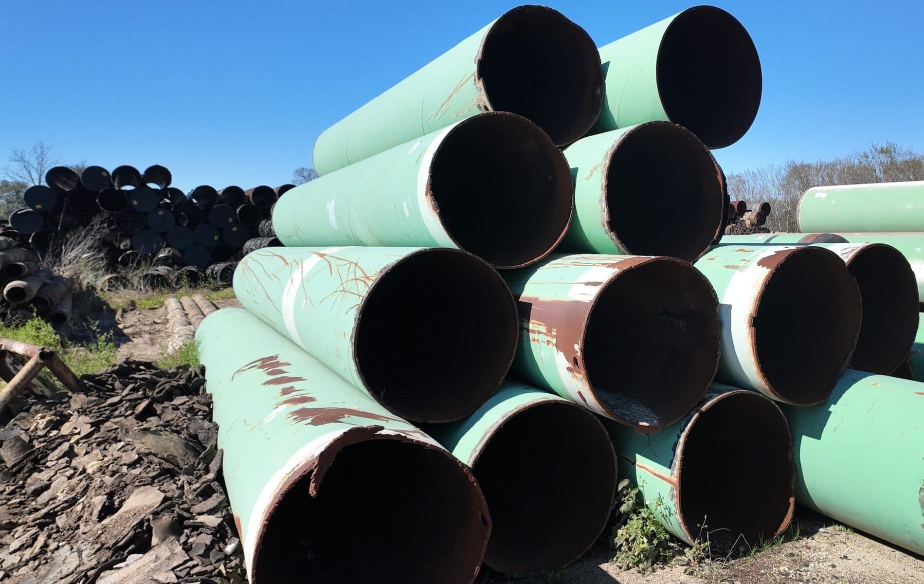 Southwest-Pipe-Services-selling-used-surplus-carbon-steel-pipes- Pipe Coating Remediation | two men working on Pipe Coating Remediation of in ground pipeline